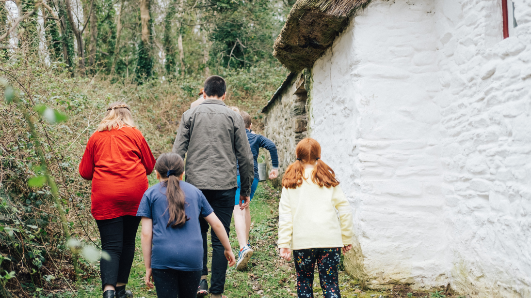 two adults and three children walking in the grounds of the folk museum