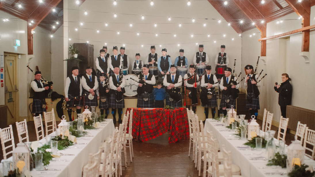 A pipe band standing on stage to celebrate burns night at the folk museum