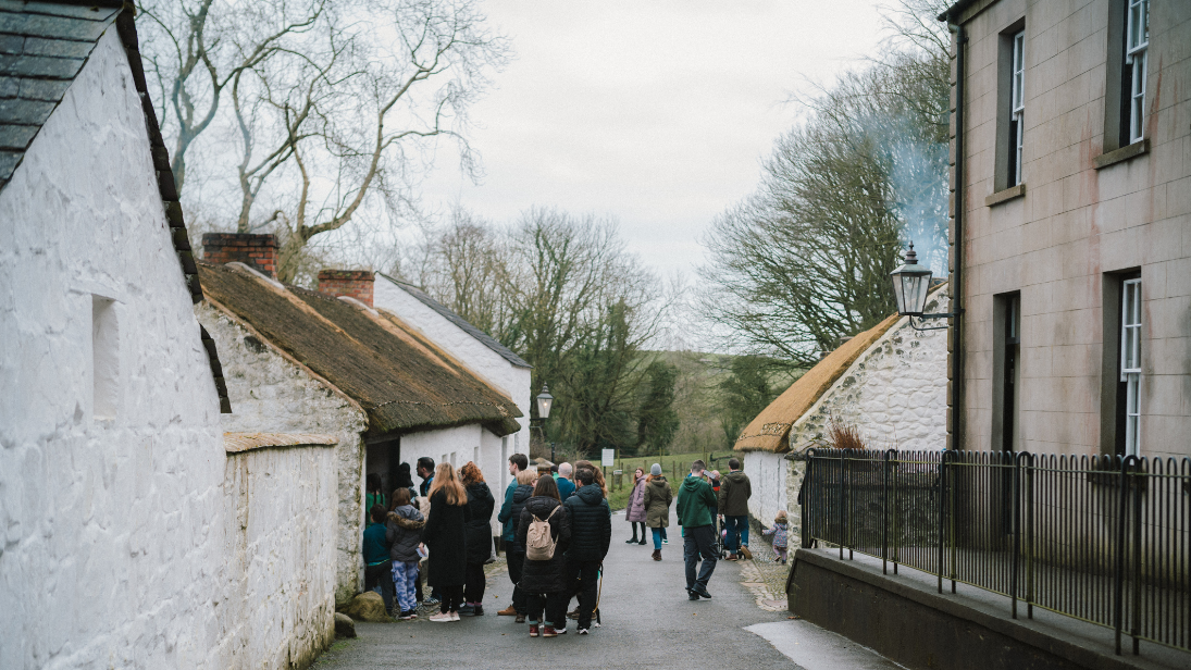 A group of people looking into a cottage at the folk museum 