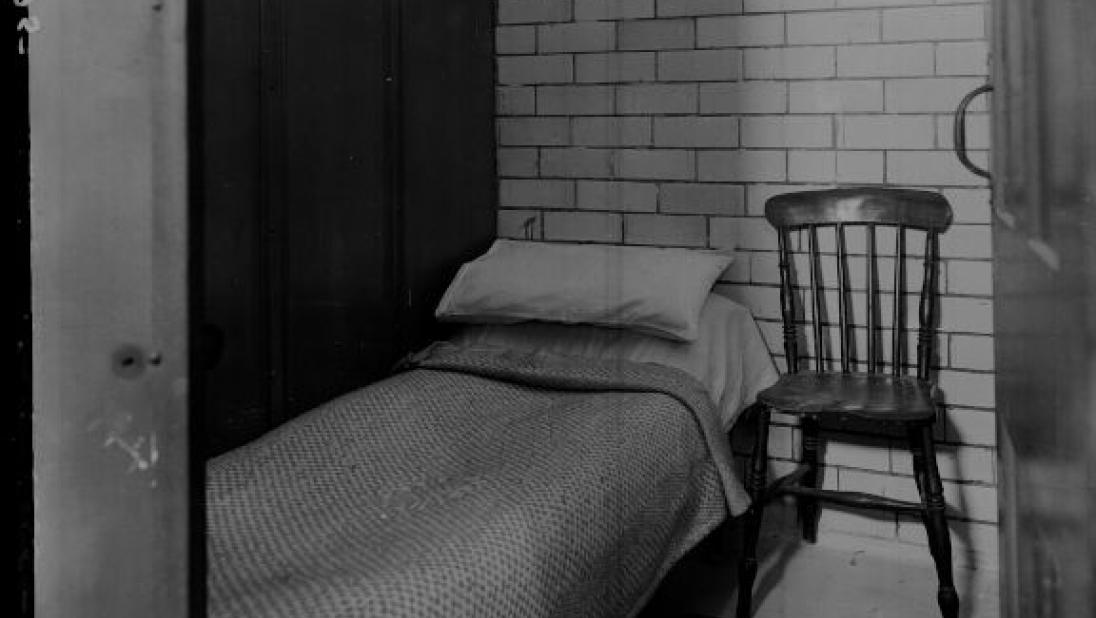 Carrick House. Interior, black and white photograph of a single bed and wooden chair