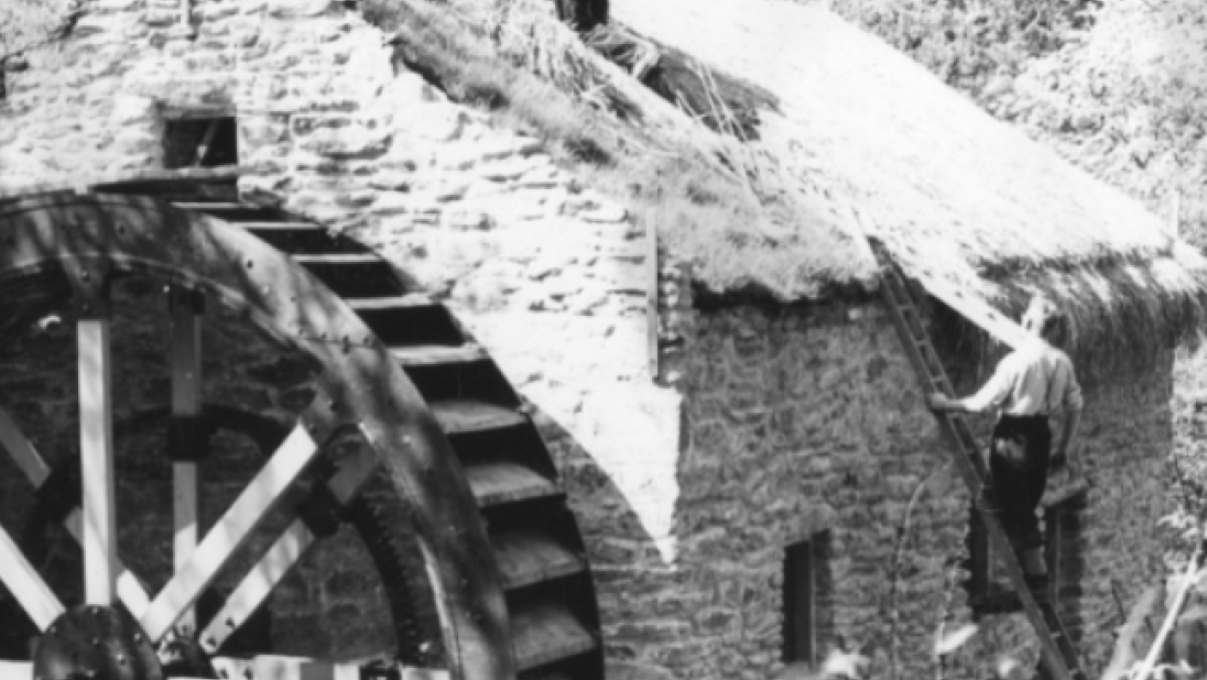 A man thatches a cottage roof at the Ulster Folk Museum, circa mid-1900s.
