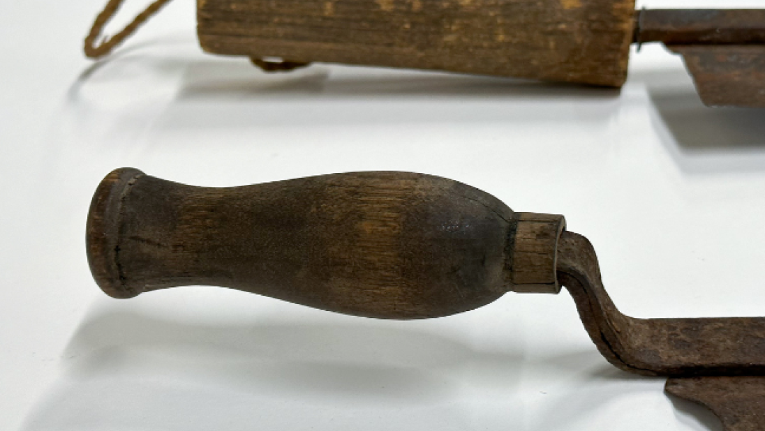 The handles of two thatching knives showing the variation of design. One is long and straight, the other shorter and curved.