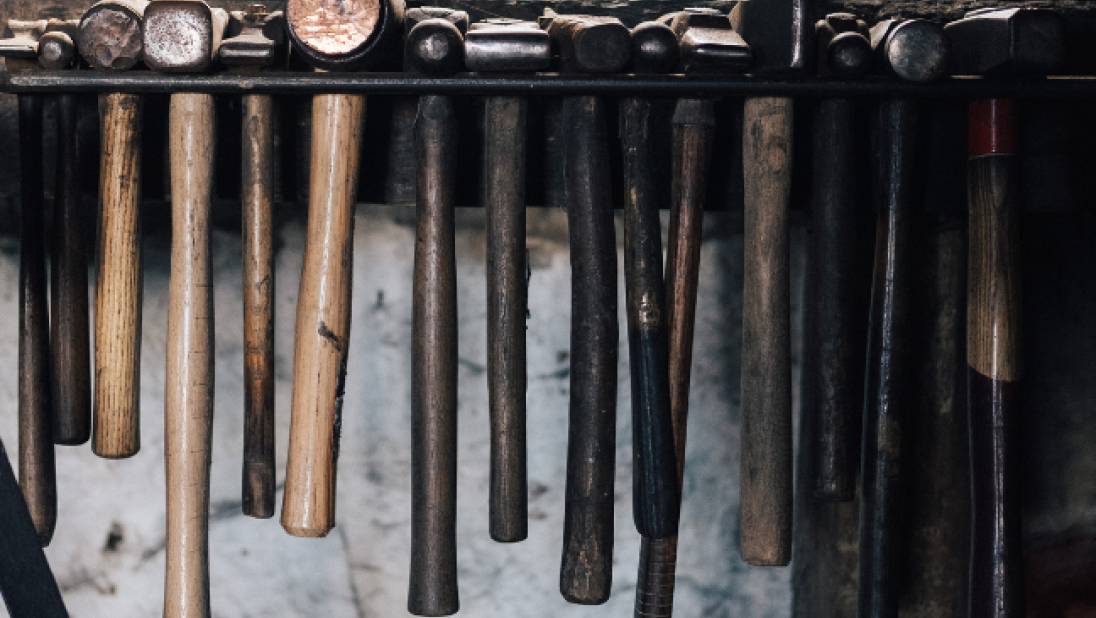 An image of hammers nestled in a holder in a forge.