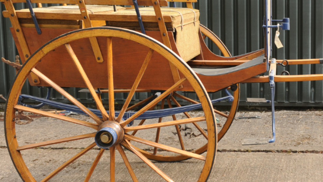 A wooden carriage for attaching to a horse.