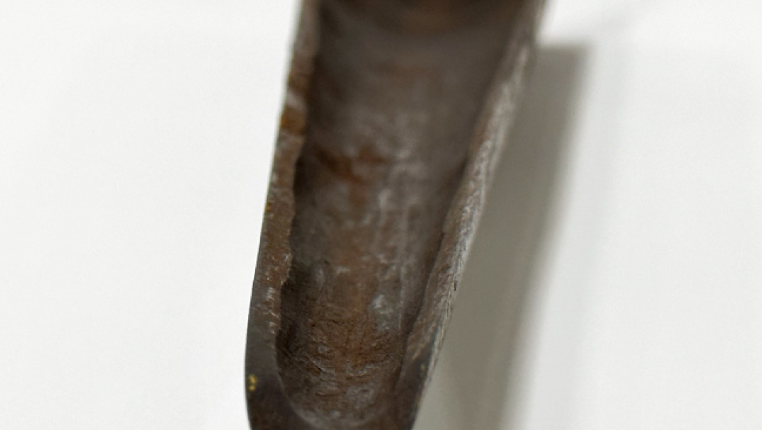 A close up of the metal end of an auger.