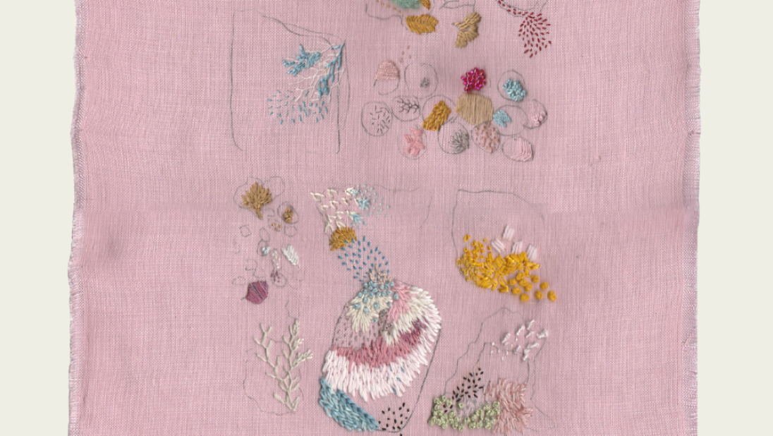 On pink linen, bright threads form shapes and patterns that refernce the sea.
