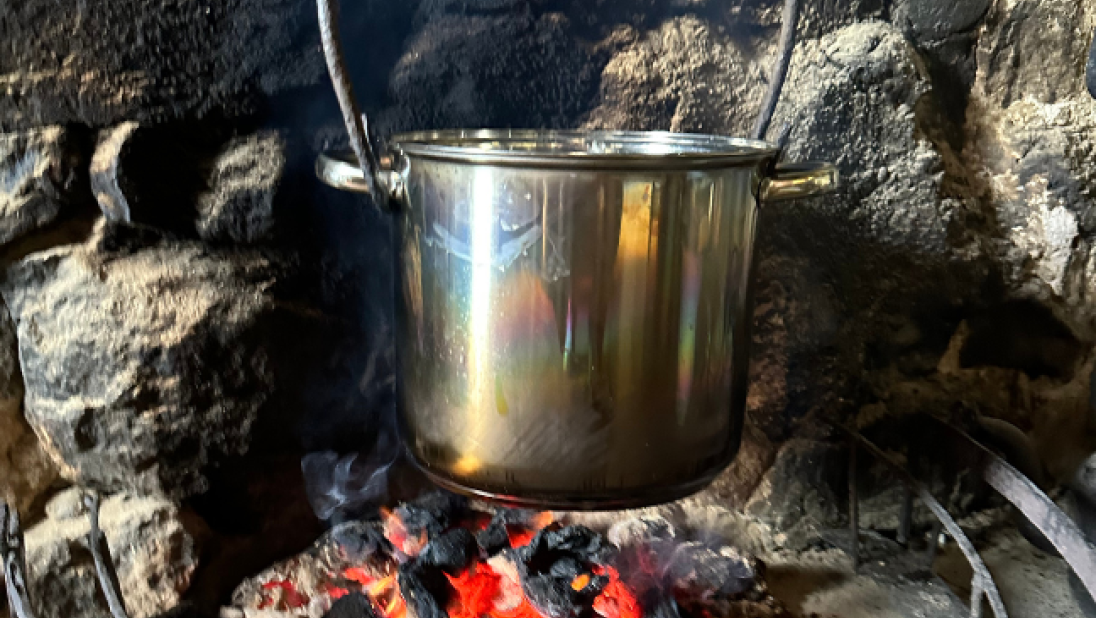 Potatoes boiling in a pot over a fire