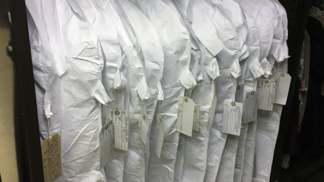 A line of clothes in white covers.