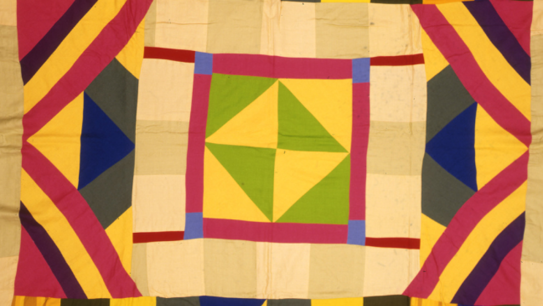 A brightly coloured quilt with a green and yellow patterned centre.