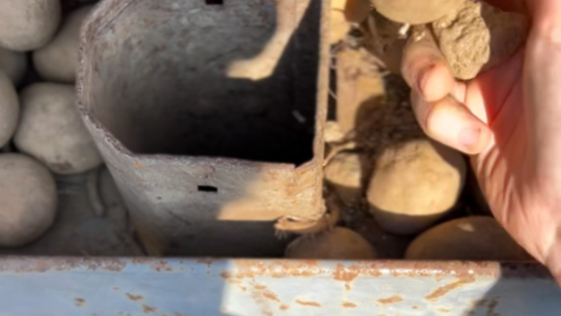 A close up of a potato chute on a tractor.
