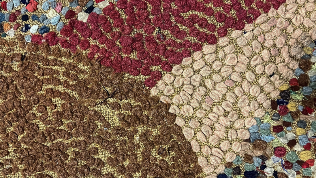 The back of a colourful rug, showing the details of the fabrics.