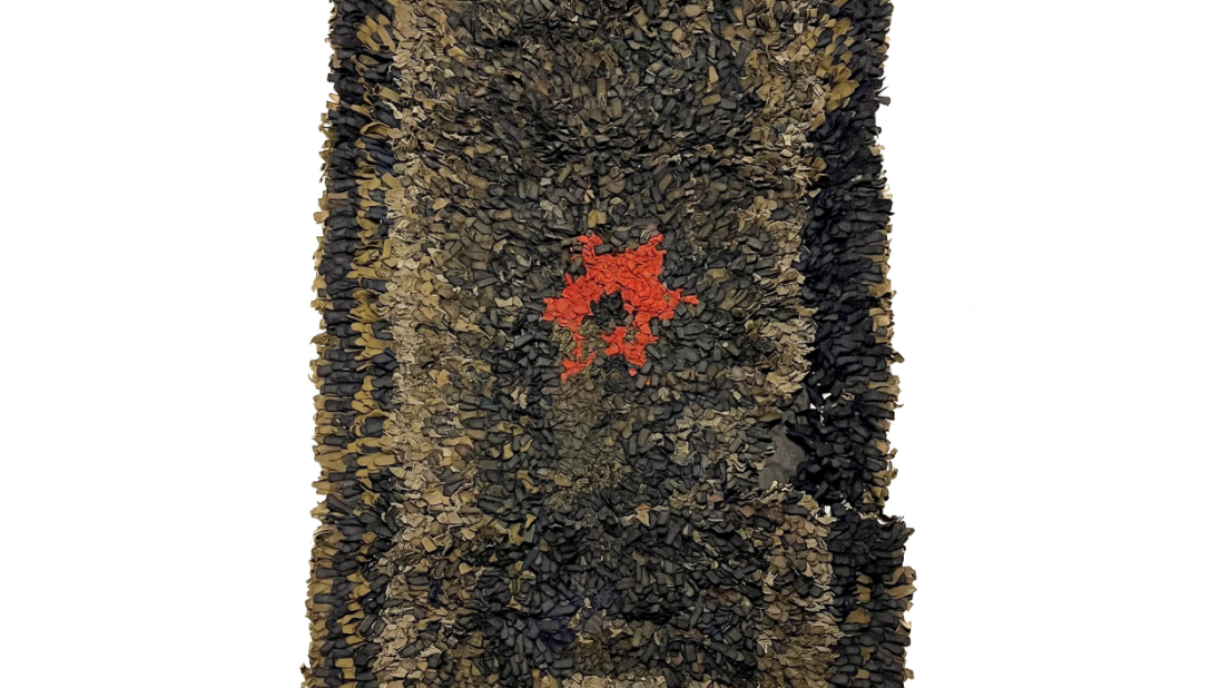 A long dark rug with an outer rectangle of green, an inner rectangle of light green, and a red star in the centre.