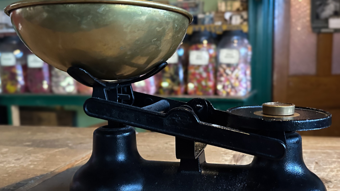 An old fashioned scale sits in a sweet shop.