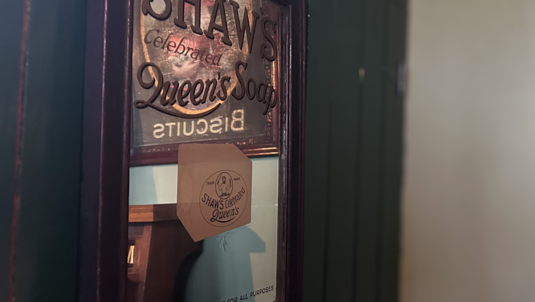 An old mirror with a hand-painted advertisement for soap.