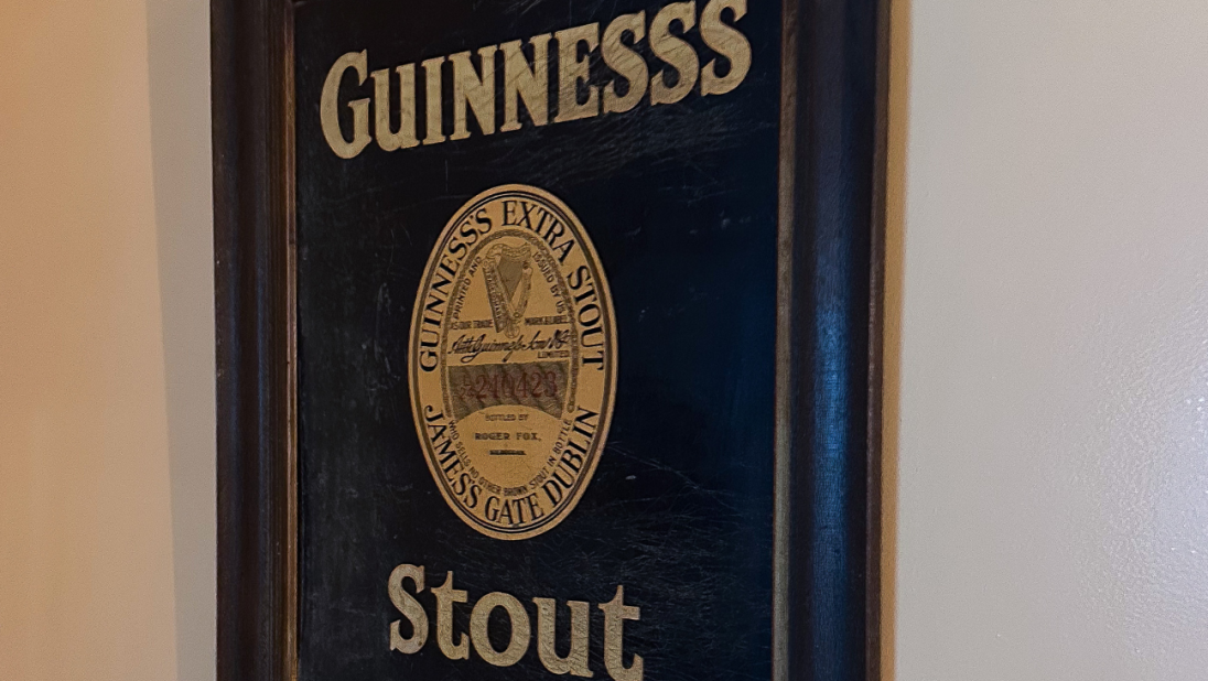 A framed advertisement for Guinness, reading 'Guinness's Stout'. The advertisement is based on an old Guiness advertisement.