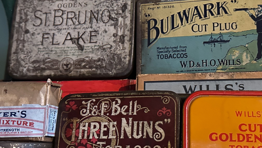 Tins of tobacco sit on a shelf.