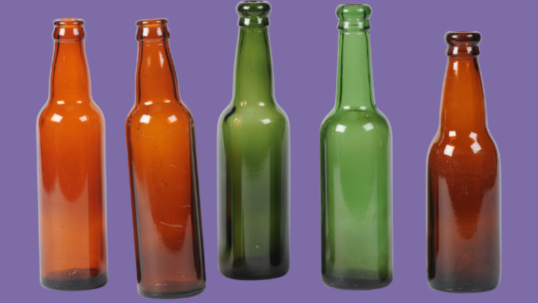 Mix of green and brown glass bottles on a purple background