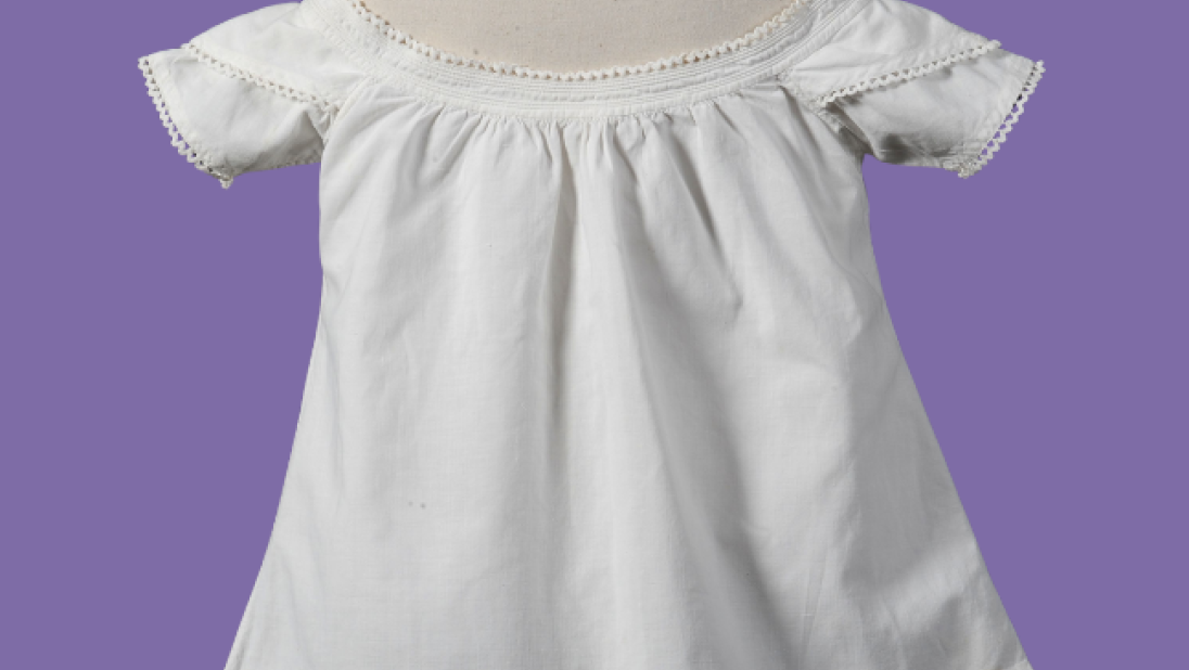 Old children's white dress on a purple background
