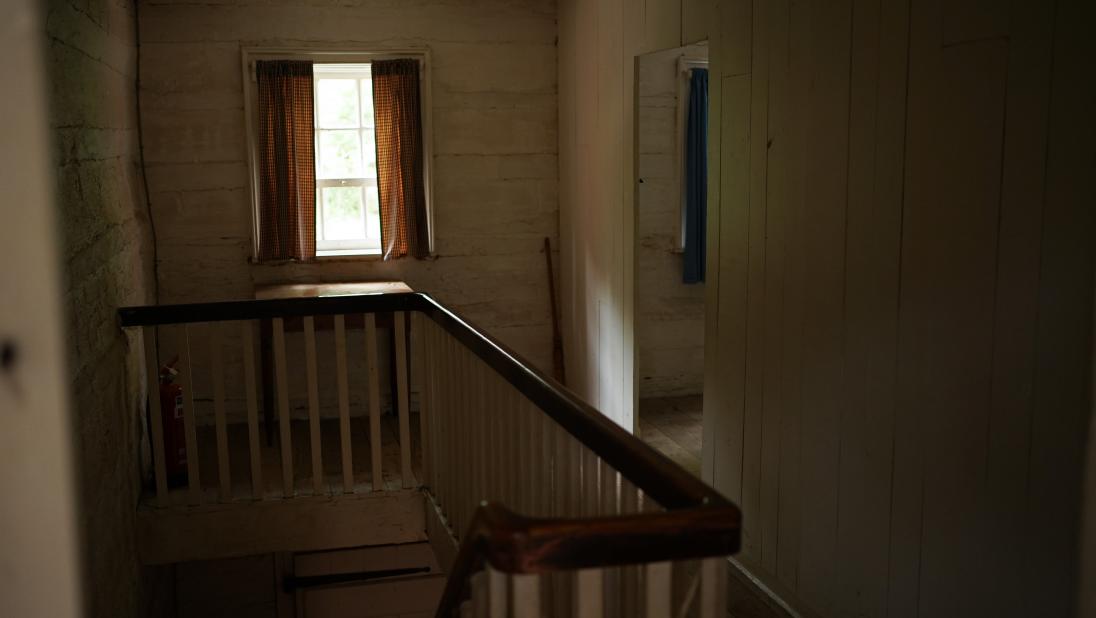 The upstair hall of a log farmhouse. It is quite small.