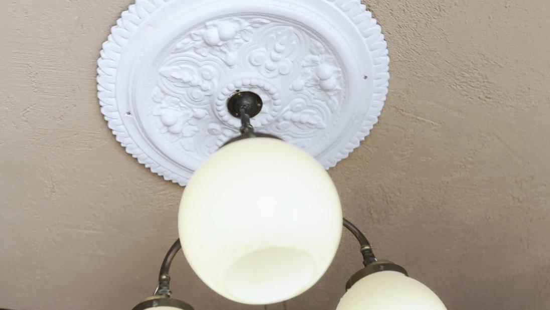 An image of a plaster decoration around a ceiling light.