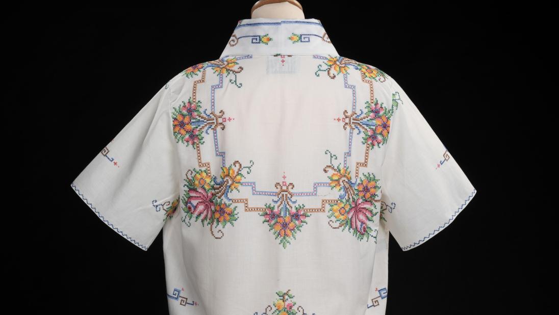 Embroidered table cloth, remade into a cropped blouse with bows on the front and collar. Presented on a bust mannequin with a black background