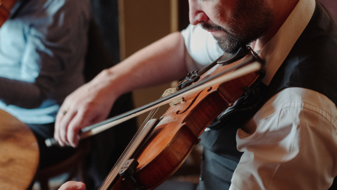 A man playing the fiddle in mccuskers pub