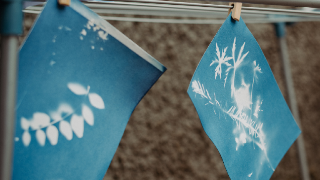 Two blue prints hanging on a line to dry