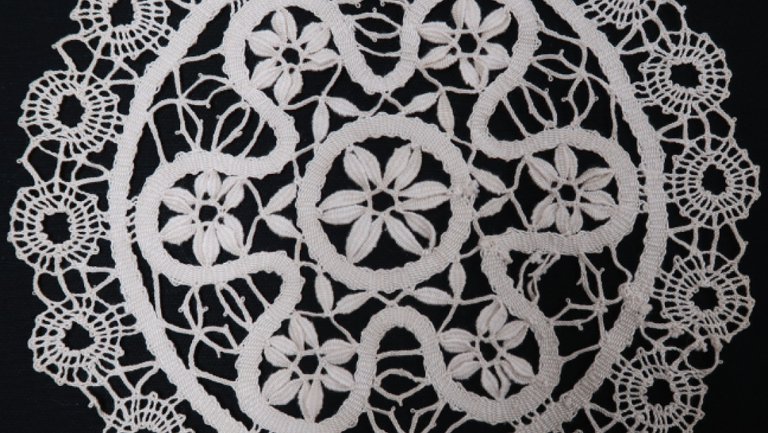 A lace doily. The pattern is intricate, making use of circles on the edges and a sort of rounded flower design in the middle.