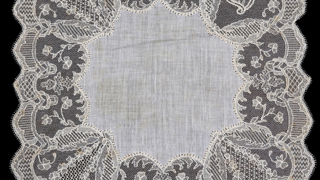 A delicate lace handkerchief with intricate, small designs. 