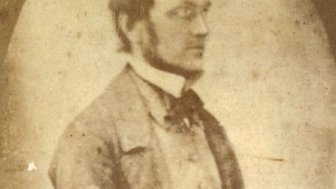 An old black and white photograph of a man. His dress is formal and he stares off to the right. 