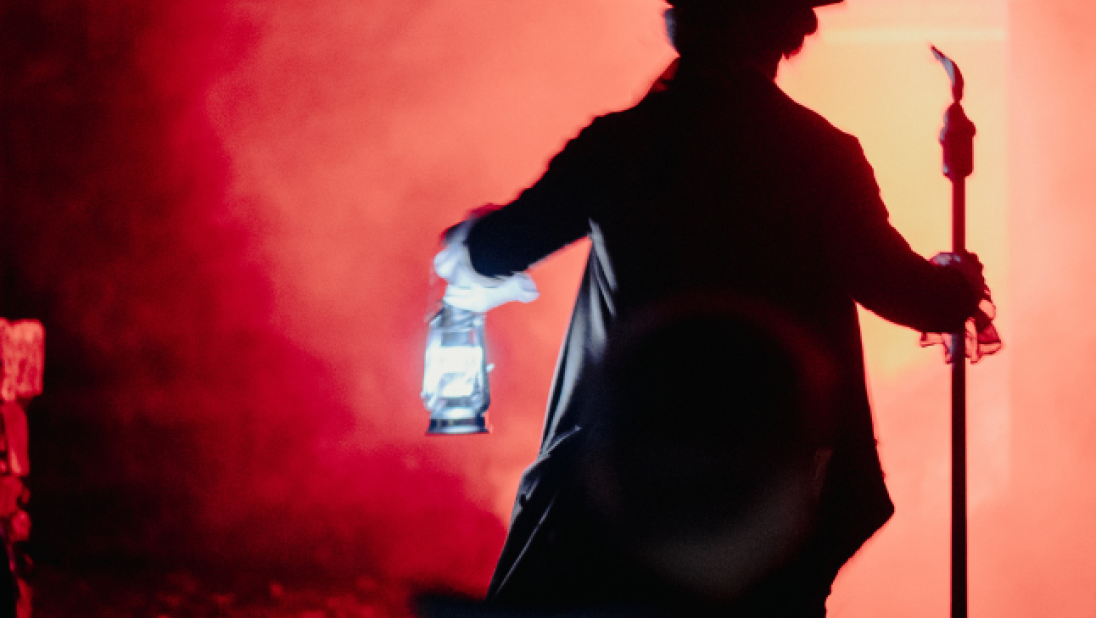 A man dressed in costume holding a torchlight