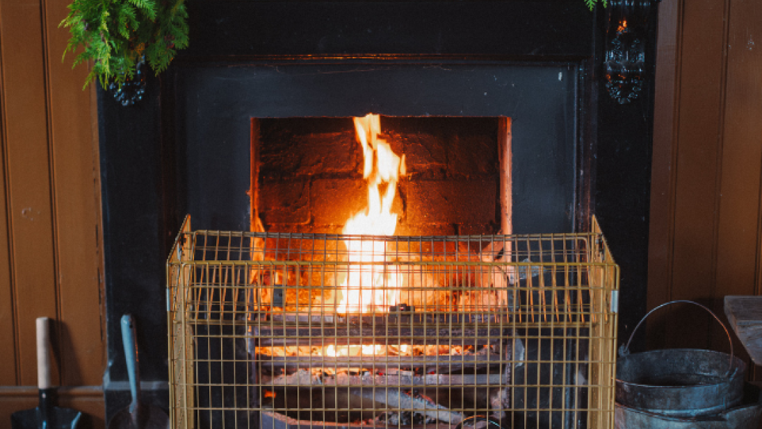 a fireplace at ulster folk museum dressed with a green garland