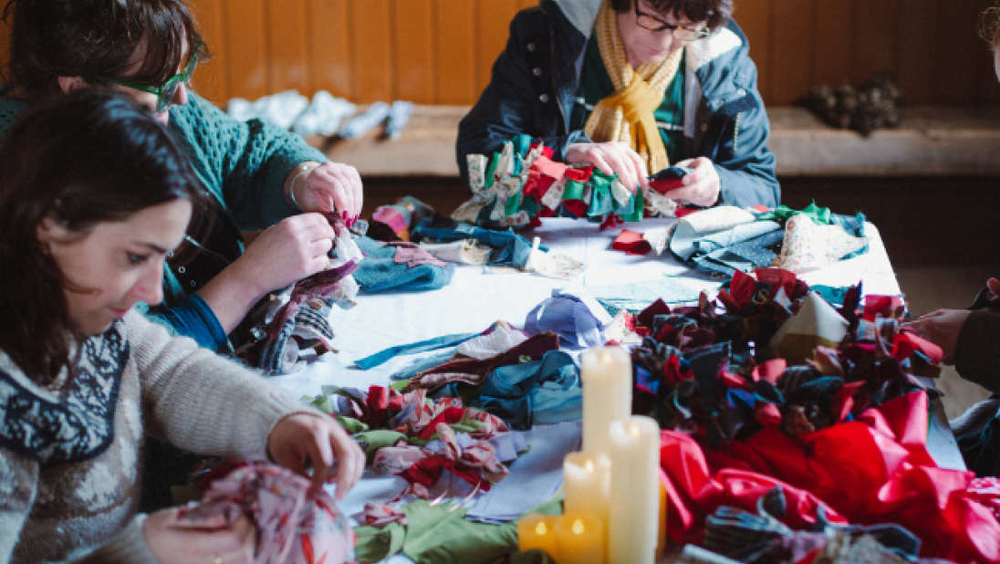 women around a table making rag wreaths