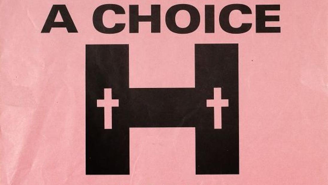 White and black poster 'The murderers have a choice, their victims had none' with two crosses on a H