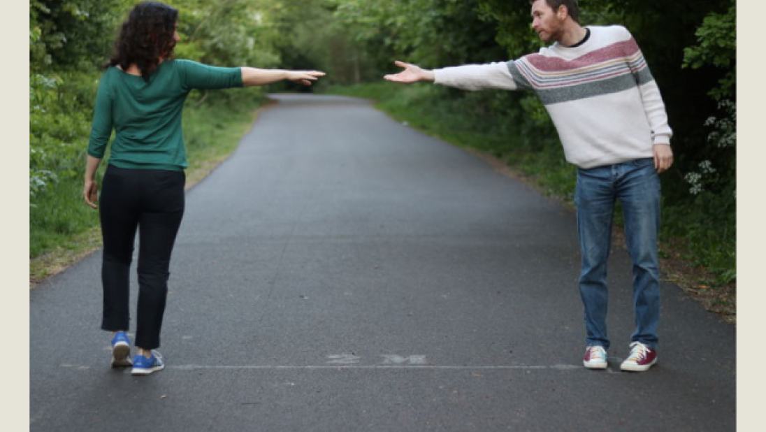 Man and woman standing two metres apart, unable to touch hands. Covid-19 Poster to reflect social distancing