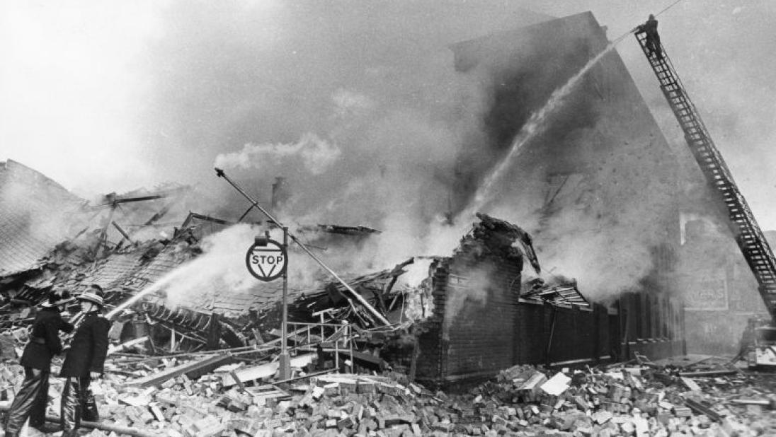 Image of two firemen dousing the smoking wreckage of Printing Works in Union Street Belfast after its destruction in a bomb attack. 