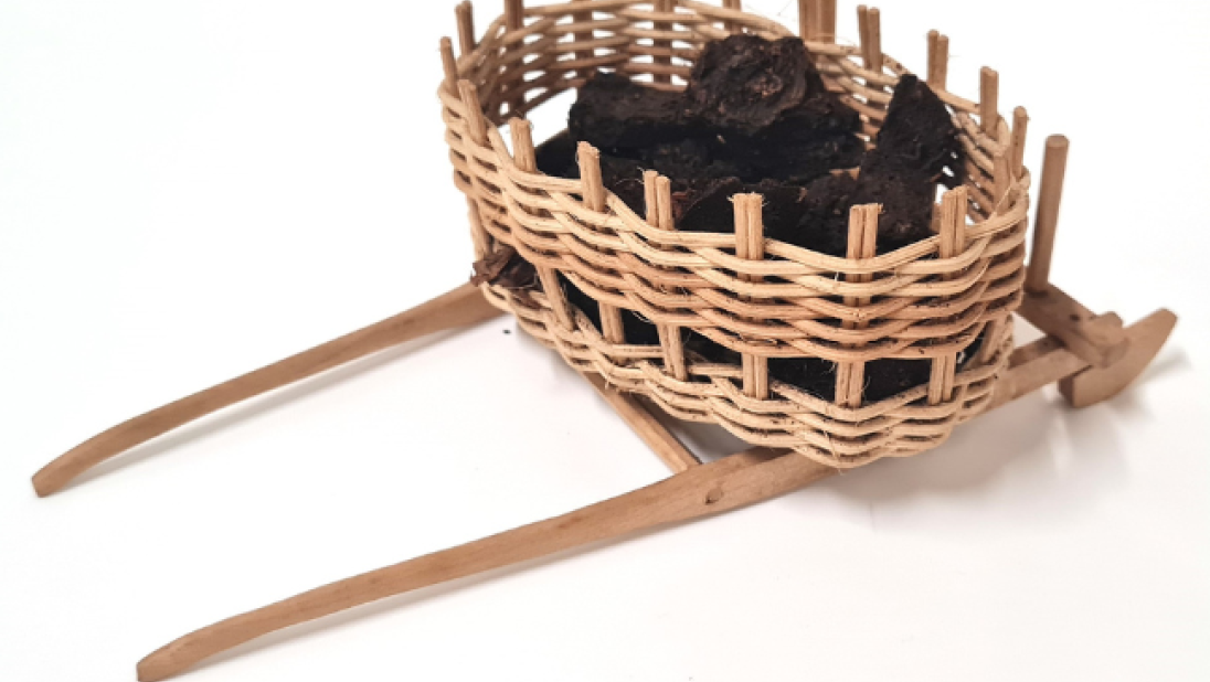 Dolls' house furniture: a wicker basket holding turf.