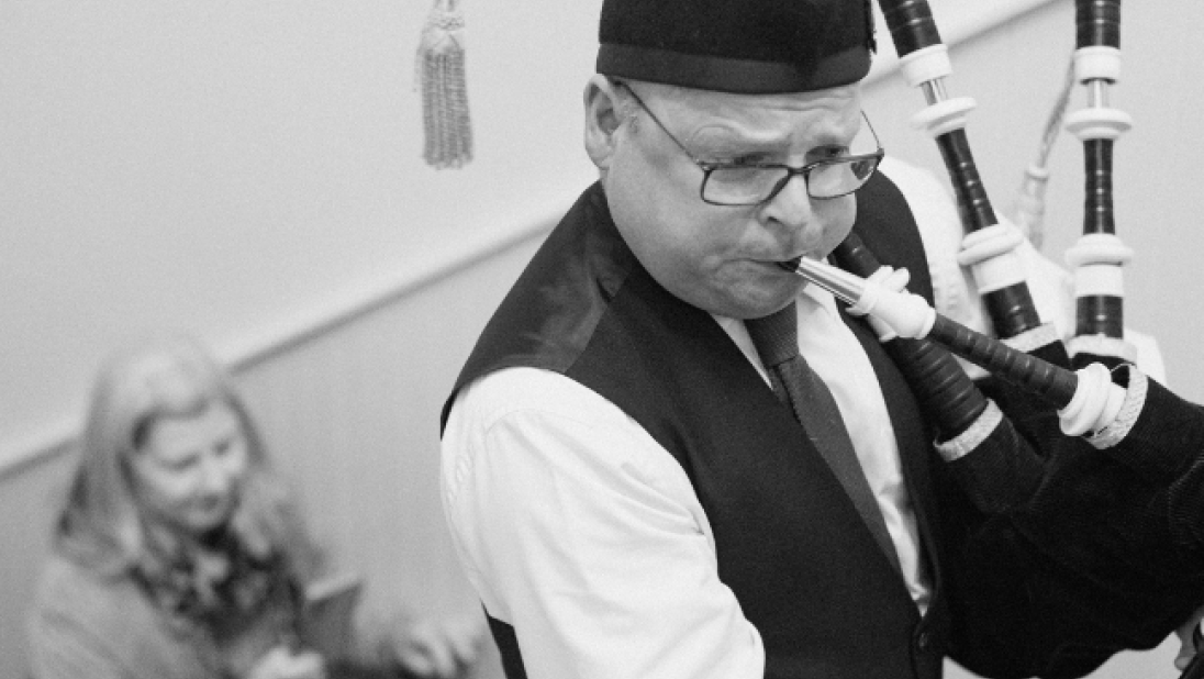 Black & white image of a man playing pipes