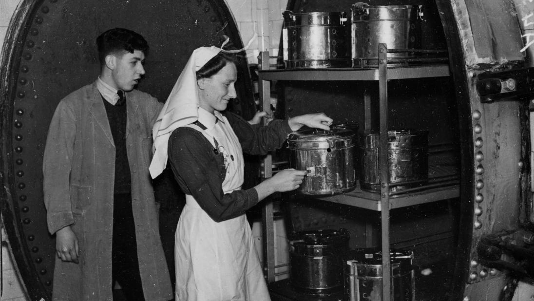 A nurse and a technician are checking sterilisation chambers, a new technology in the 1900s.