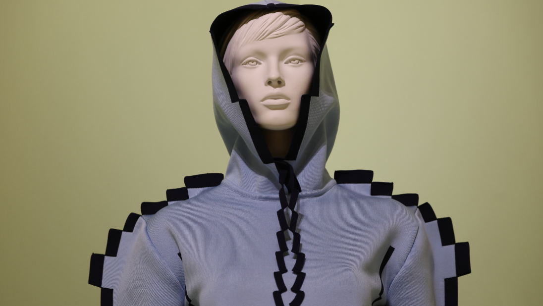 A close up of a white mannequin with a face, modelling the blue and black Pixelated hoodie from Loewe's Spring/Summer 2023 collection