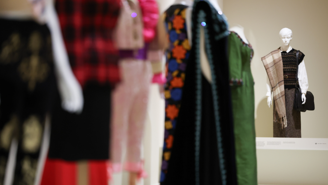 Colourful garments on white mannequins in a cream painted room