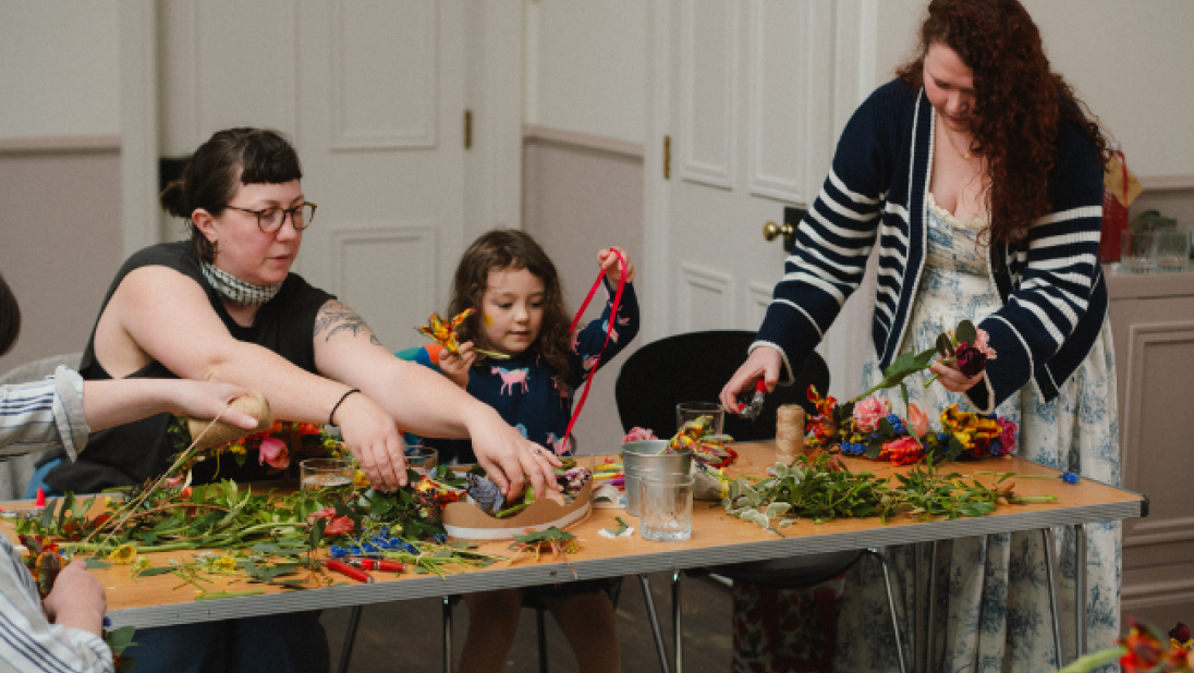 two women and a young girl doing crafts at a table