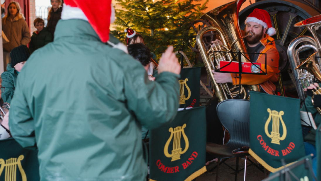 A man conduciting a brass band at christmas