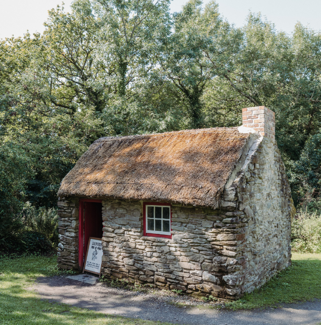 A very small, thatched cottage.