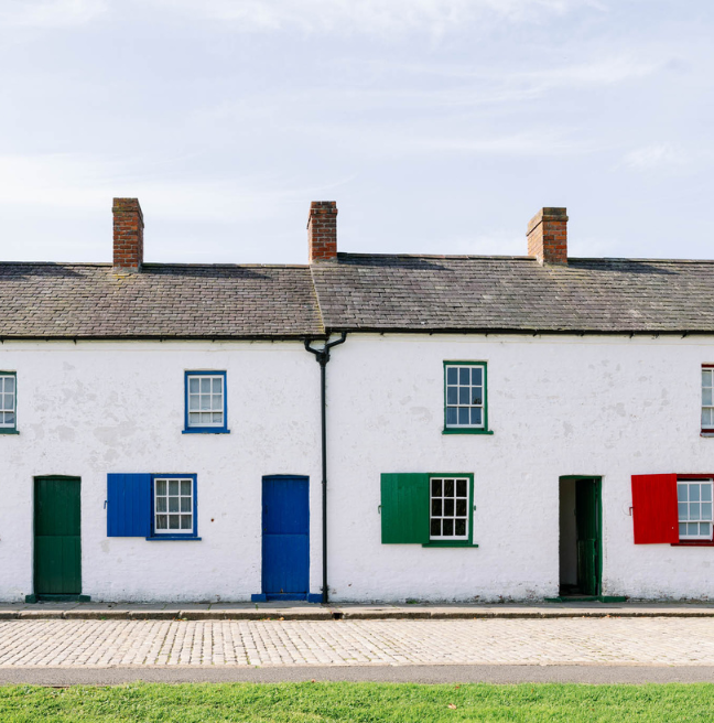 A row of whitewashed houses with colourful doors.