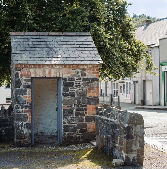 A small stone hut with a slate roof.