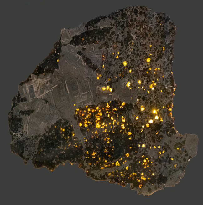 A meteorite with light shining through in thinner spots.