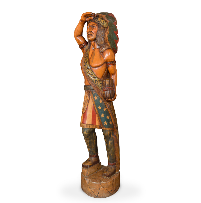 A large carving of a 'Cigar Store Indian' - a stereotypical depiction of a Native American man used to promote and sell tobacco. 