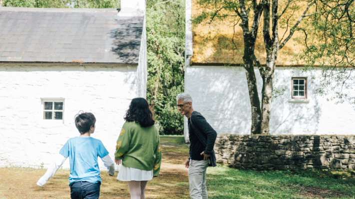 A family exploring Ulster American Folk Park on a sunny day