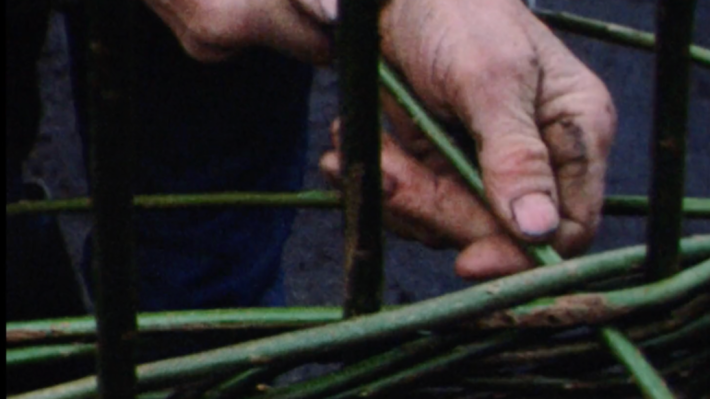 Close up of a mans dirty hands weaving 